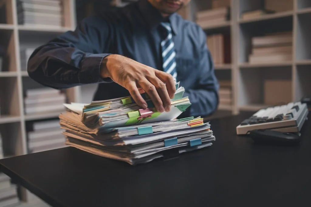 Fleet manager reviewing driver qualification files at desk